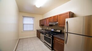 kitchen with stainless steel appliances, wood cabinets and window at 2800 ontario road apartments in adams morgan washington dc