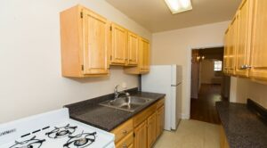 kitchen with wood cabinetry, gas range and refrigerator at 4020 Calvert street apartments in washington dc