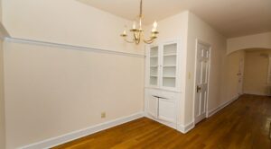 built in shelving in dining area with chandelier and hardwood floors at 4020 Calvert street apartments in washington dc