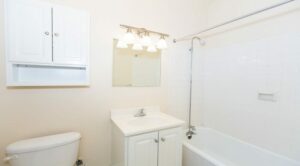 bathroom with tub, toilet, vanity, mirror and medicine cabinet at the klingle apartments in cleveland park washington dc
