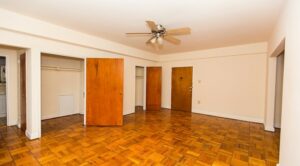 vacant living area with large closets, hardwood floors, celling fan and view of front entrance at 1401 sheridan apartments in washington dc