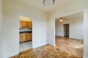 vacant dining area with lighting, view of kitchen and view of living area with ceiling fan at 1401 sheridan apartments in washington dc