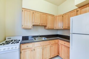kitchen with oak cabinets, gas range and refrigerator at 1401 sheridan apartments in washington dc