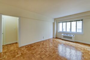 vacant living area with hardwood floors and large windows at sherry hall apartments in washington dc