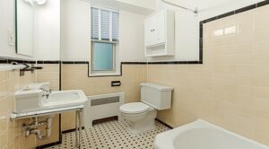 bathroom with tub, toilet, medicine cabinet, sink and mirror at 2800 woodley road apartments in washington dc