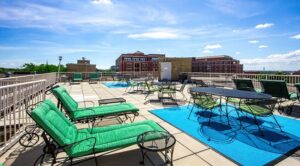 rooftop lounge with social seating, tables and lounge chairs at 2800 woodley road apartments in washington dc