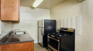 kitchen with refrigerator, gas range and tile backsplash at 2801 pennsylvania apartments in randle highlands washington dc