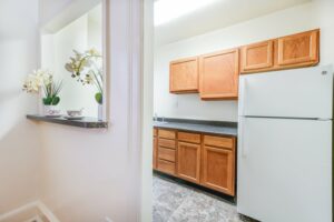 kitchen with refrigerator, wood cabinets and breakfast bar at 3213 Wisconsin apartments in cleveland park washington dc