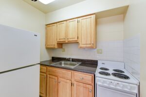 kitchen with refrigerator, stove and tile backsplash at alpha house apartments in columbia heights washington dc