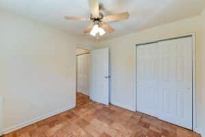 bedroom with large closet, ceiling fan and wood flooring at alpha house apartments in columbia heights washington dc