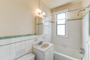 bathroom with tub, sink, toilet, mirror and window at the eddystone apartments in washington dc