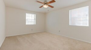 bedroom with carpet, ceiling fan and large windows at grandview village apartments in shipley terrace washington dc