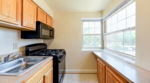 kitchen with breakfast bar, large windows and gas range at shipley park apartments in washington dc
