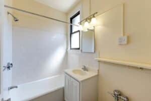 bathroom with sink, medicine cabinet, tub, toilet and window at the klingle apartments in cleveland park washington dc