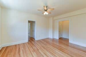 vacant living area with hardwood floors, ceiling fan and view of front entrance at the klingle apartments in cleveland park washington dc