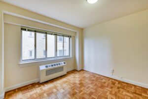 vacant bedroom with hardwood floors and large windows at sherry hall apartments in washington dc