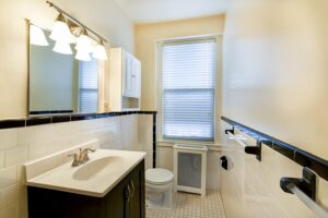 bathroom with vanity, mirror, toilet, medicine cabinet and window at 2701 Connecticut apartments in washington dc