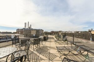 rooftop lounge with tables, social seating and views of dc at 2701 Connecticut apartments in washington dc