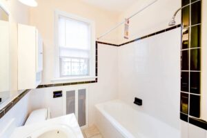 bathroom with tub, toilet, medicine cabinet and window at 2800 ontario road apartments in adams morgan washington dc