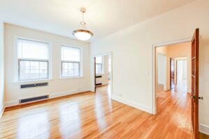 vacant dining area with hardwood floors, large windows, french doors and hanging lighting at 2800 ontario road apartments in adams morgan washington dc
