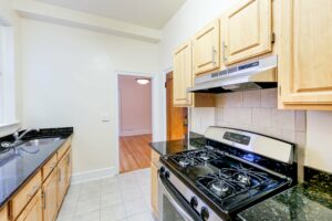 kitchen with gas range, tile backsplash and wood cabinets at 2800 ontario road apartments in adams morgan washington dc