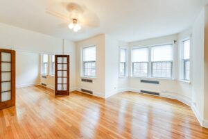 vacant living area with hardwood floors ,ceiling fan and large windows at 2800 ontario road apartments in adams morgan washington dc