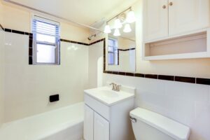 bathroom with tub, toilet, vanity, mirror and window at cambridge square apartments in bethesda maryland