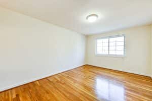 vacant bedroom with hardwood floors and large window at cambridge square apartments in bethesda maryland