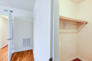 hallway view of large closet with shelving and hard wood floors at cambridge square apartments in bethesda maryland
