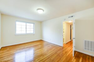 vacant bedroom with wood floors and large window at cambridge square apartments in bethesda maryland