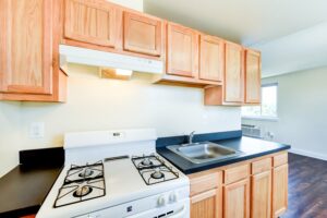 kitchen with gas range and view of dining area at longfellow apartments in brightwood washington dc