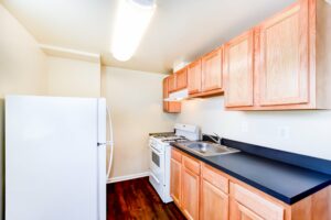 kitchen with refrigerator, gas range and wood flooring at longfellow apartments in brightwood washington dc