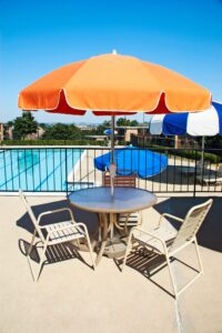 swimming pool deck with tables, chairs and umbrellas at washington view apartments in washington dc