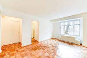 vacant living area with large windows and hardwood flooring at 2800 woodley road apartments in washington dc