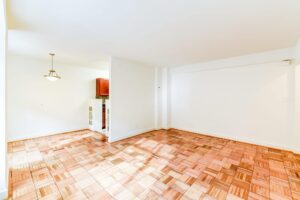 vacant living area with hardwood floors and view of dining area and kitchen at 2800 woodley road apartments in washington dc