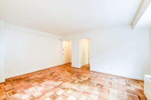 vacant living area with hardwood floors and view of front entrance at 2800 woodley road apartments in washington dc
