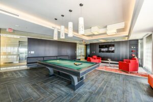 club room with social seating, tv and pool table at the agora at the collective apartments in the capital riverfront washington dc