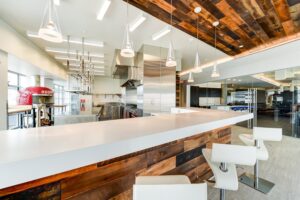 clubroom with demonstration kitchen, bar seating and pizza oven at the agora at the collective apartments in the capital riverfront washington dc