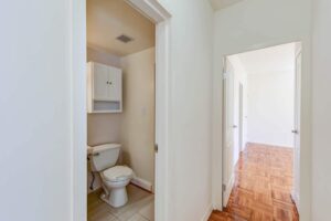 hallway view of bathroom and vacant bedroom with hardwood floors at clarence house apartments in washington dc