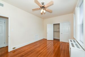 vacant bedroom with hardwood floors, large closet, windows and ceiling fan at the norwood apartments in washington dc