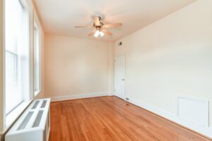 vacant bedroom with hardwood flooring, large windows and ceiling fan at the norwood apartments in washington dc