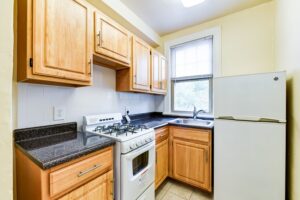 kitchen with refrigerator, gas range, tile backsplash and window at the foreland apartments in capitol hill washington dc