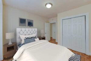 bedroom with bed, nightstands, closet and hardwood floors at sherry hall apartments in washington dc