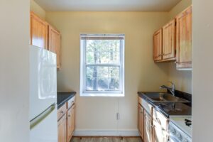 kitchen with fridge, gas range, window and wood cabinets at 4031 davis place apartments in glover park washington dc