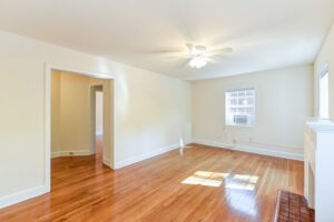 vacant living area with hardwood floors, ceiling fan and large windows at4031 davis place apartments in glover park washington dc