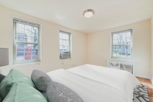 bedroom with bed, large windows and hardwood flooring at 1401 sheridan apartments in washington dc