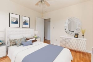bedroom with bed, nightstand, dresser and large mirror at penn view apartments in washington dc