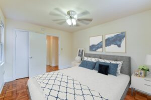 bedroom with bed, nightstand, ceiling fan and hardwood floors at the colonnade apartments in washington dc