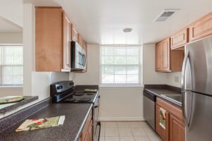 kitchen with refrigerator, electric range, breakfast bar and window at t street apartments in washington dc