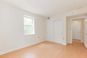 vacant bedroom with hardwood floors, closet and window at the oaks apartments in washington dc